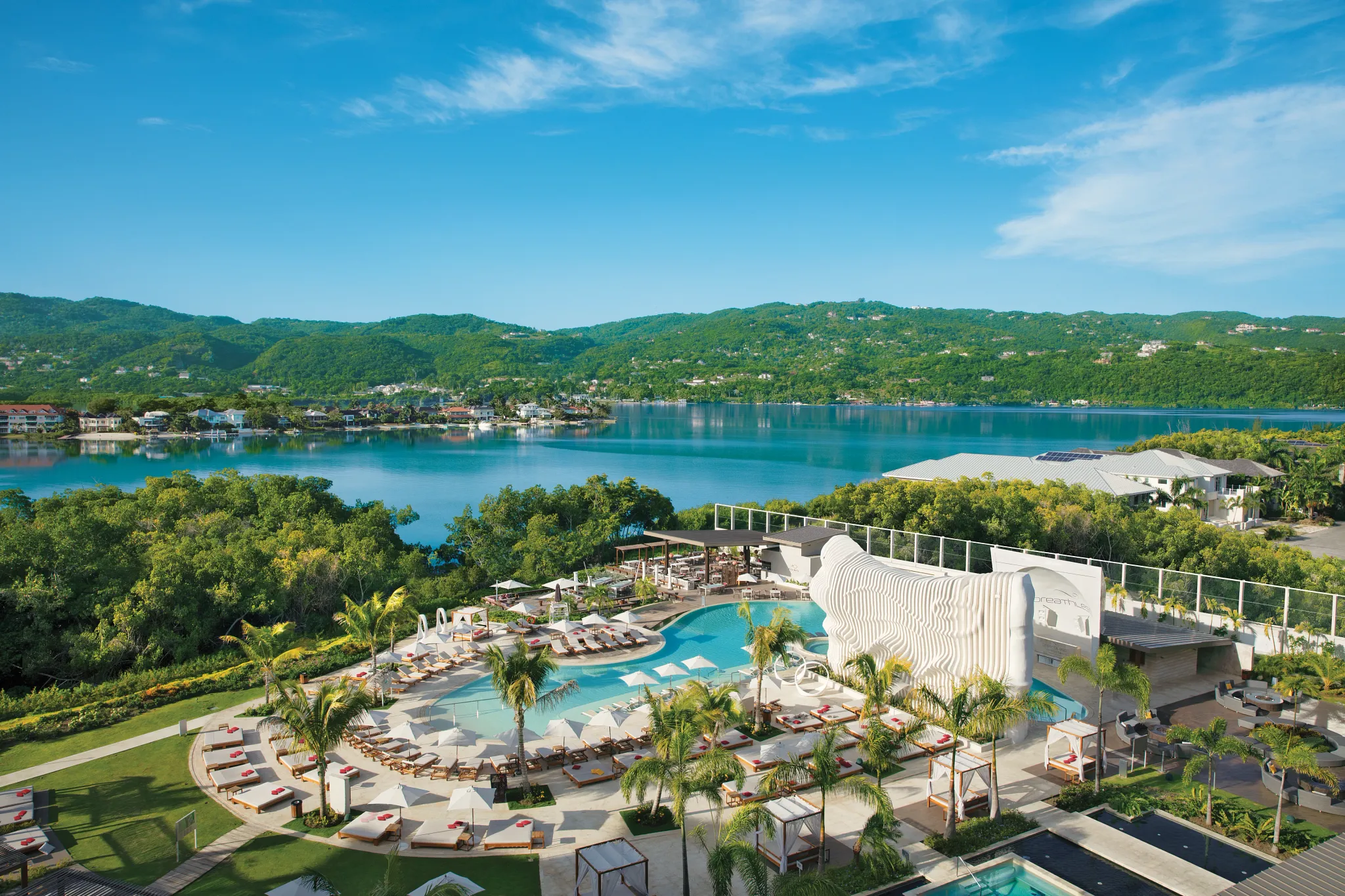 Aerial view of the luxury pool at Breathless Montego Bay Resort & Spa overlooking turquoise Caribbean waters.
