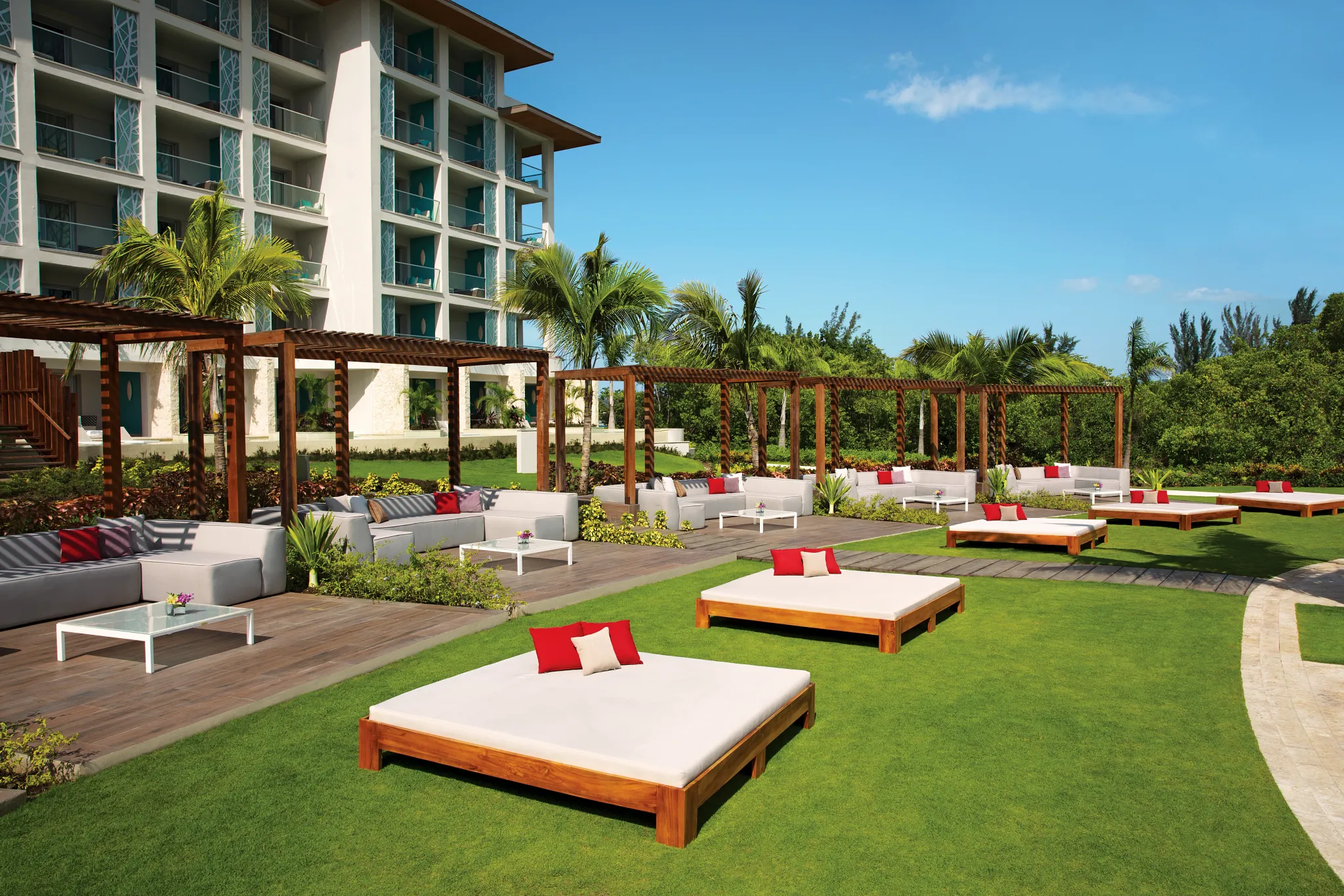 Modern poolside cabanas and daybeds at Breathless Montego Bay surrounded by lush greenery.