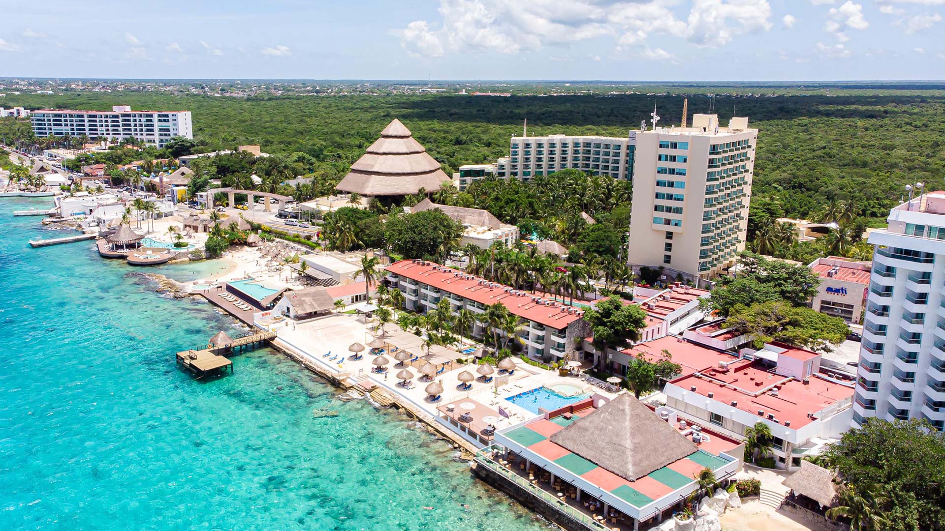 El Cid La Ceiba Beach Hotel Cozumel beachfront property with palm trees, swimming pool, and Caribbean Sea views.