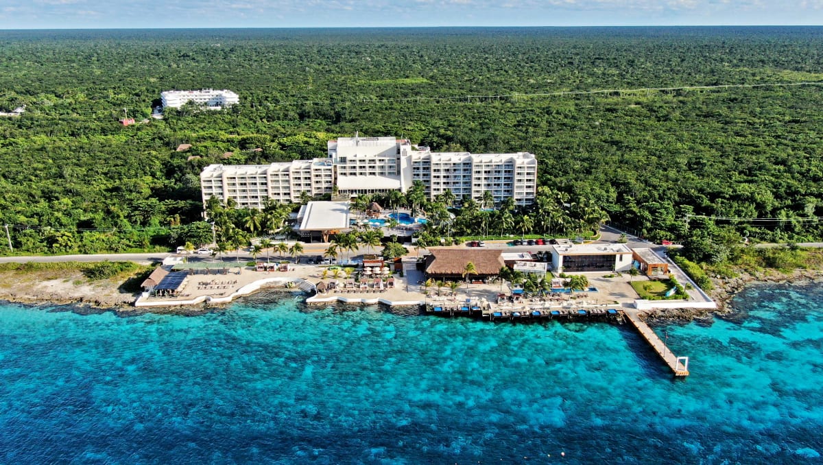 Fiesta Americana Cozumel All Inclusive resort with beachfront pools, palm trees, and Caribbean views on Cozumel Island, Mexico.