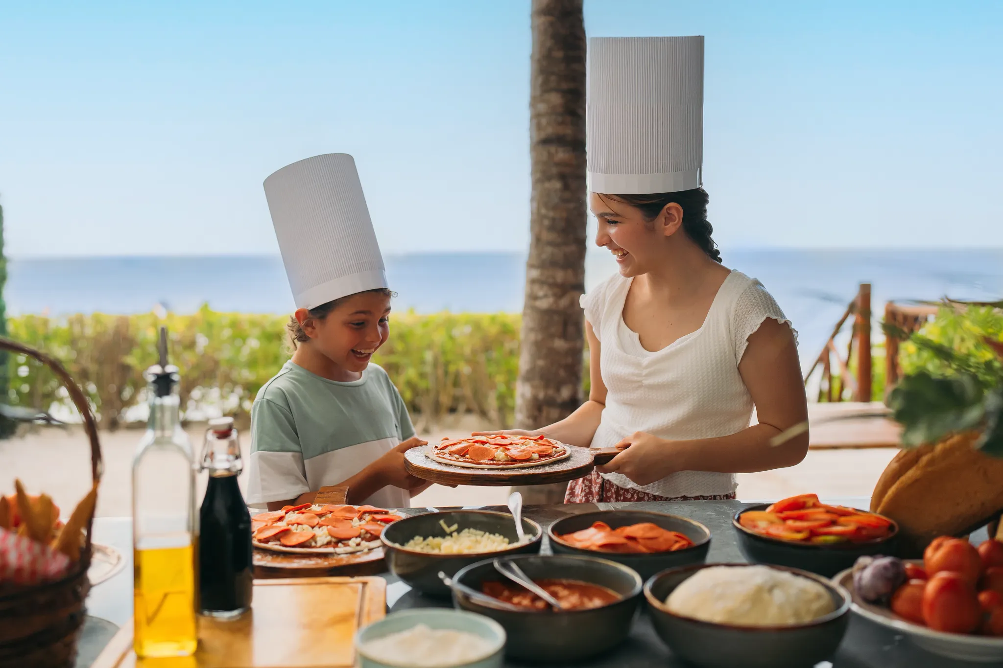 Child participating in a pizza-making activity at Dreams Cozumel Cape Resort & Spa kids club.
