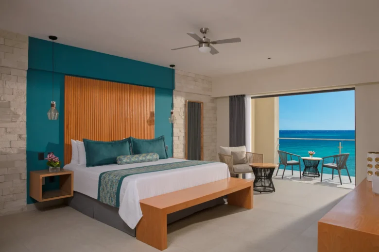 Master Suite Ocean View bedroom with king bed and balcony at Dreams Cozumel Cape Resort & Spa.