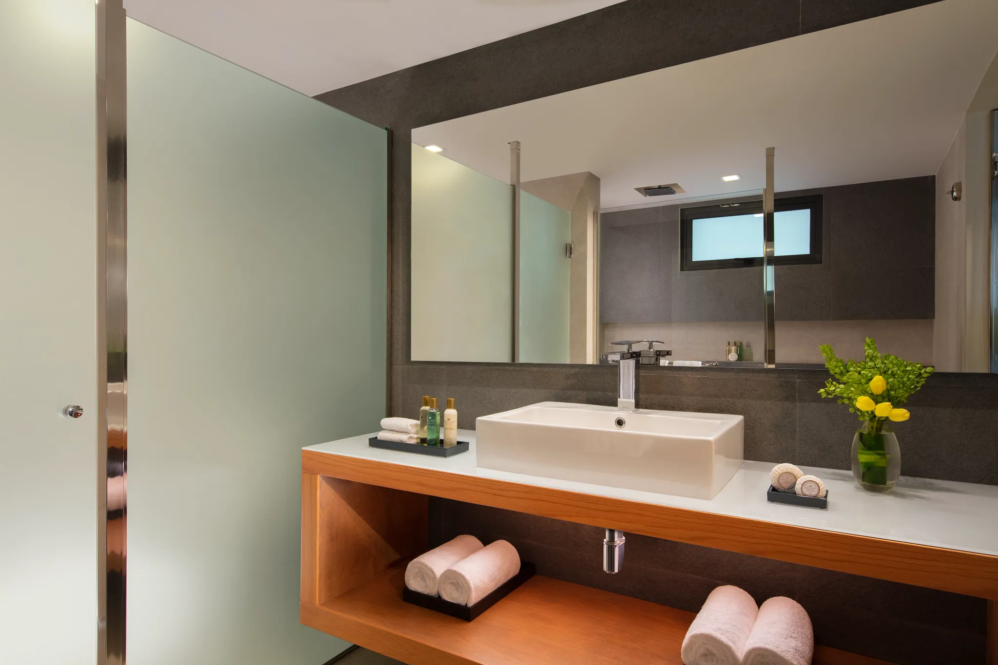 Modern bathroom with sleek vanity and glass shower in Preferred Club Junior Suite Ocean View at Dreams Cozumel Cape.