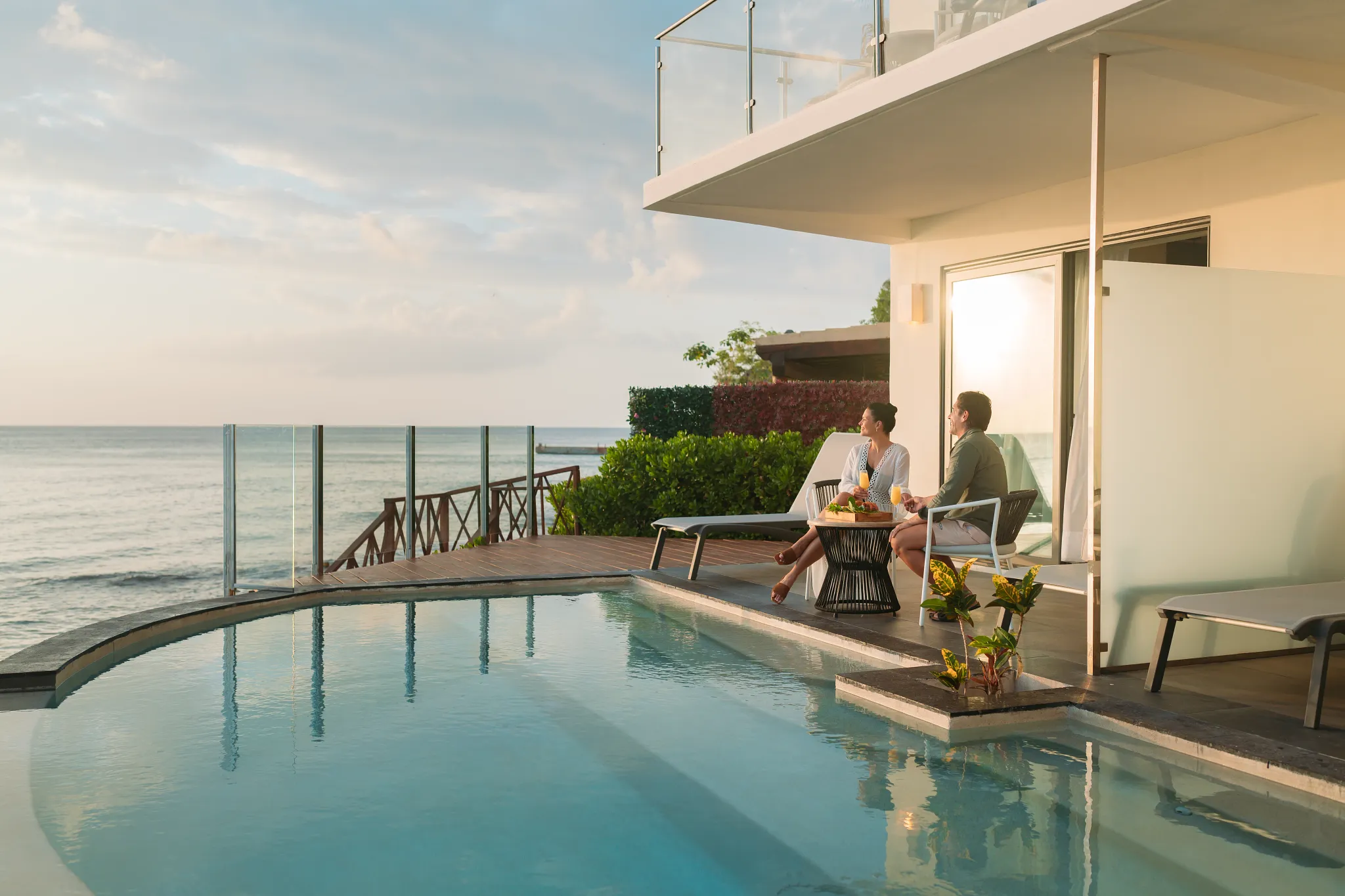 Couple relaxing on a private terrace overlooking the sunset at Dreams Cozumel Cape Resort & Spa.