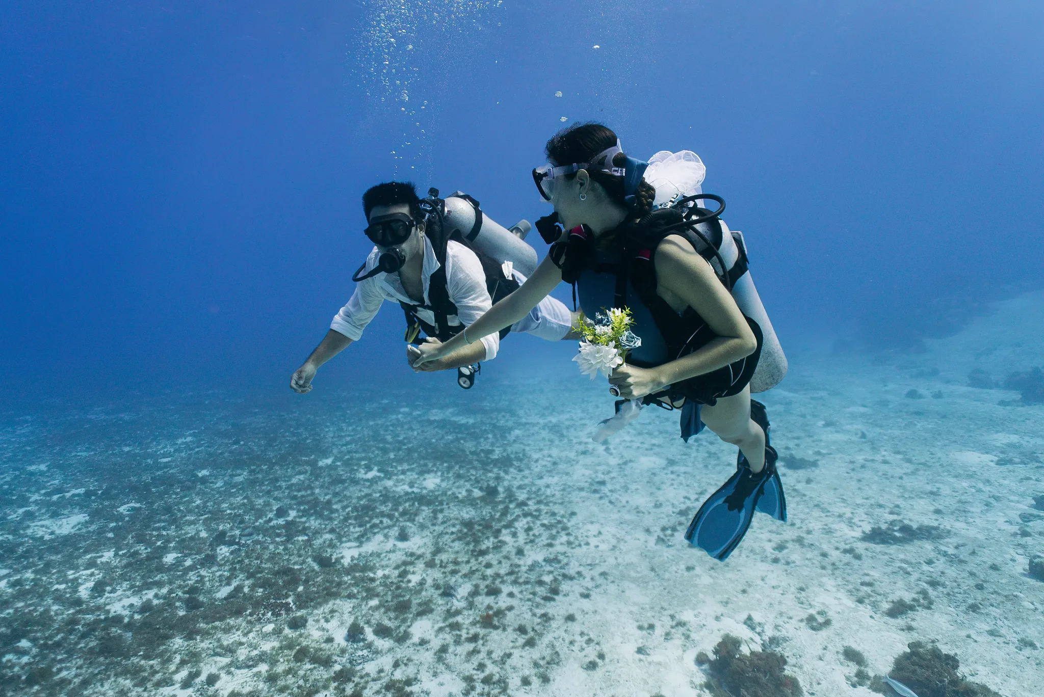 Couple scuba diving in clear Caribbean waters near Dreams Cozumel Cape Resort & Spa.